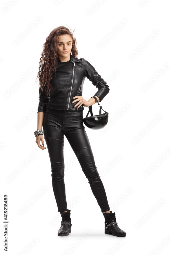 Full length portrait young of a woman with long curly hair holding a biker helmet Full length portrait young of a woman with long curly hair holding a biker helmet