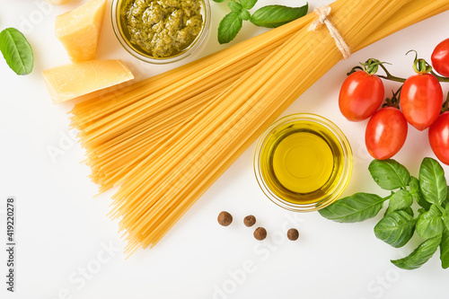 Spaghetti, fresh tomato, herbs and spices. Composition of healthy food ingredients isolated on white background, top view