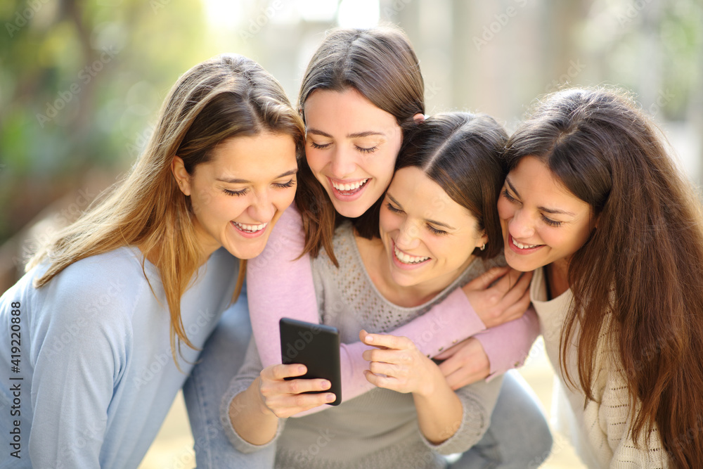 Four happy women checking smart phone content Four happy women checking smart phone content