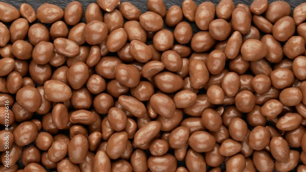 Peanuts in chocolate on a black background, top view. Peanuts in chocolate on a black background, top view.