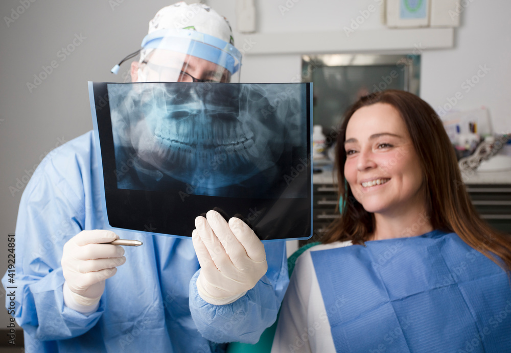 doctor with oral xray and personal protective equipment teaches oral x