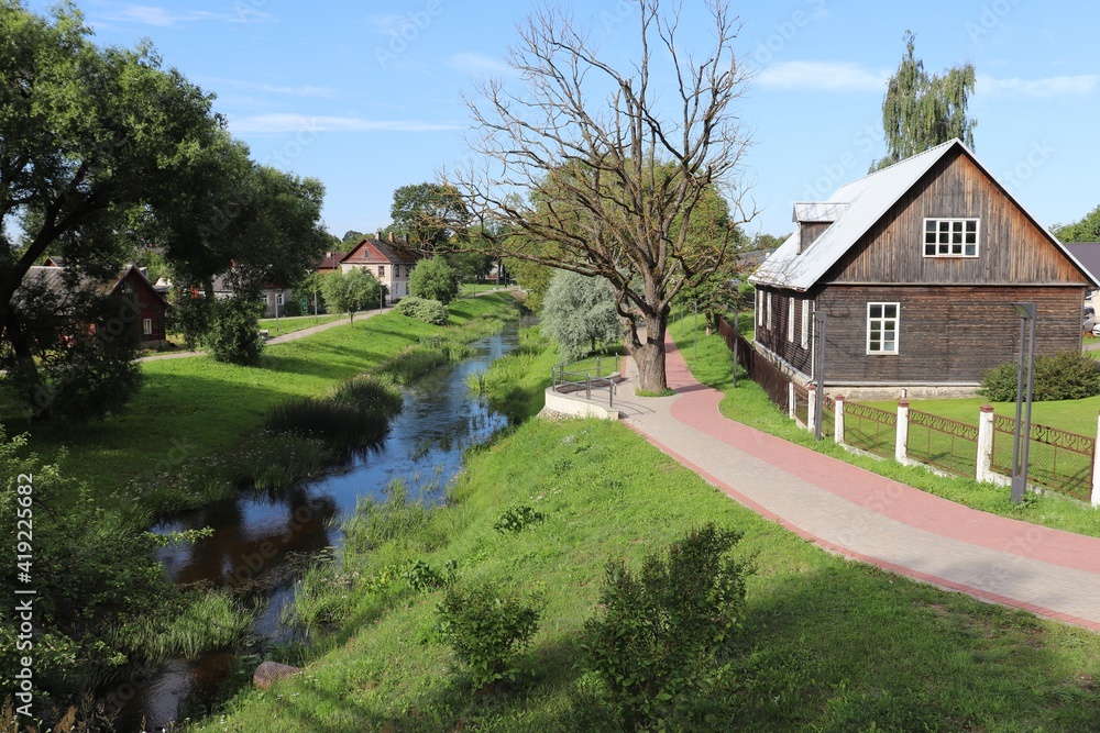 Private houses on the banks of a small river flowing through the Latvian city of Rezekne on summer days 2019