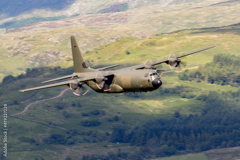 Royal Air Force (RAF) C130 Hercules four engined transporter flying low ...