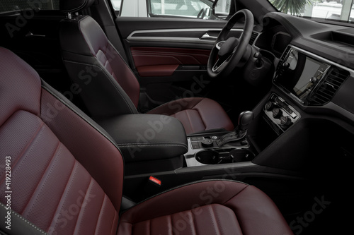 side view of the interior of a luxurious car with red leather seats, automatic transmission, steering wheel and touch screen © JesusCarreon