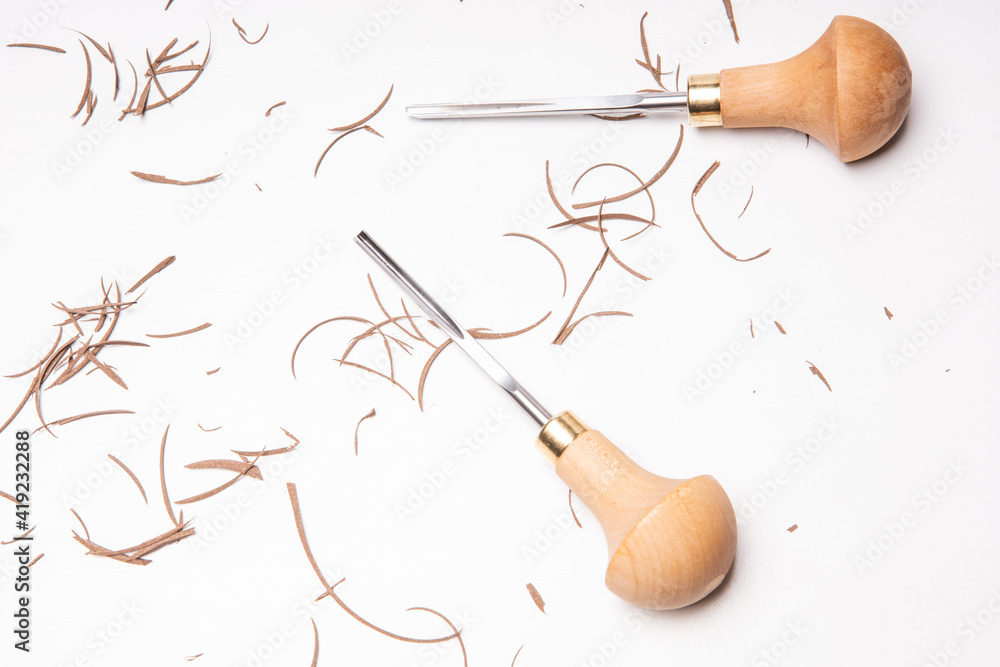 Linocut tools with linoleum pieces on table after cuting brown linoleum  Stock Photo