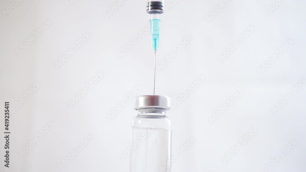 Close-up of a Syringe with a Needle Drawing a Medicine from a Glass Vial Close-up of a Syringe with a Needle Drawing a Medicine from a Glass Vial