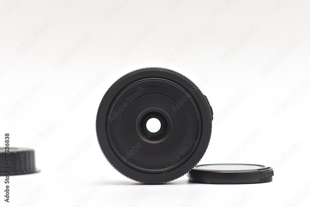 Untitled small black 24mm lens for DSLR camera with caps removed on white background