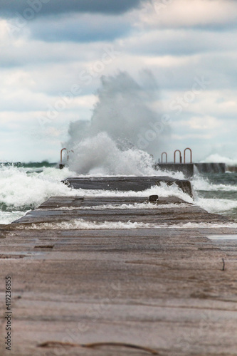 powerful waves almost swallowing a jetty in Michigan Lake.