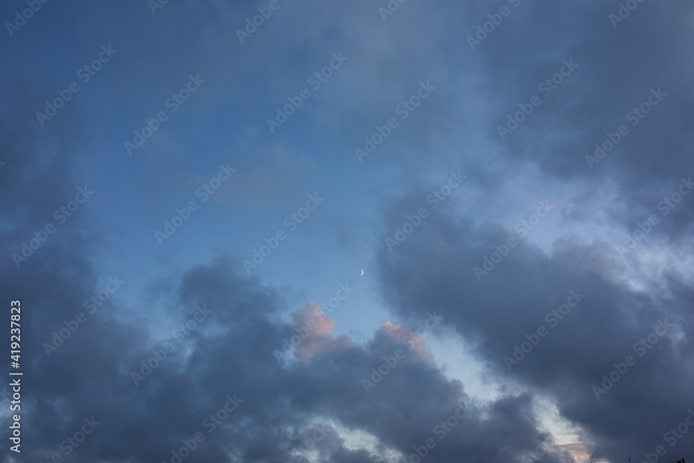 Dreamy, fairy tail like, blue and purple clouds on a sunset sky with bright moon Dreamy, fairy tail like, blue and purple clouds on a sunset sky with bright moon