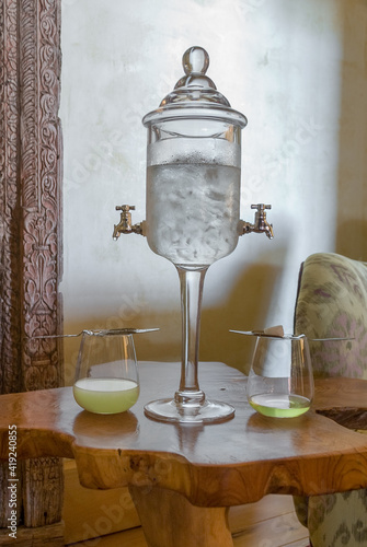 Before and After Preparation of Absinthe Cocktail by Melting a Sugar Cube on an Absinthe Spoon with a Traditional Absinthe Fountain