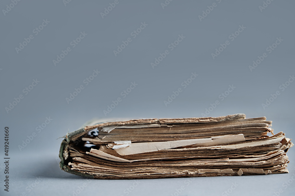 A very old book with torn pages lies on the table A very old book with torn pages lies on the table