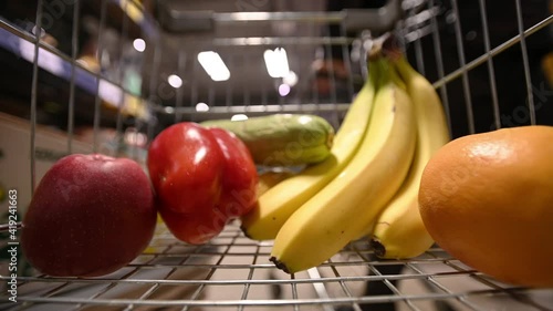 sale, shopping, consumerism and people concept - man with shopping cart at grocery store or supermarket