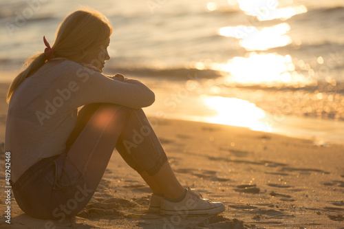 Photography Relax woman sitting alone thinking at the beach during calm sunset