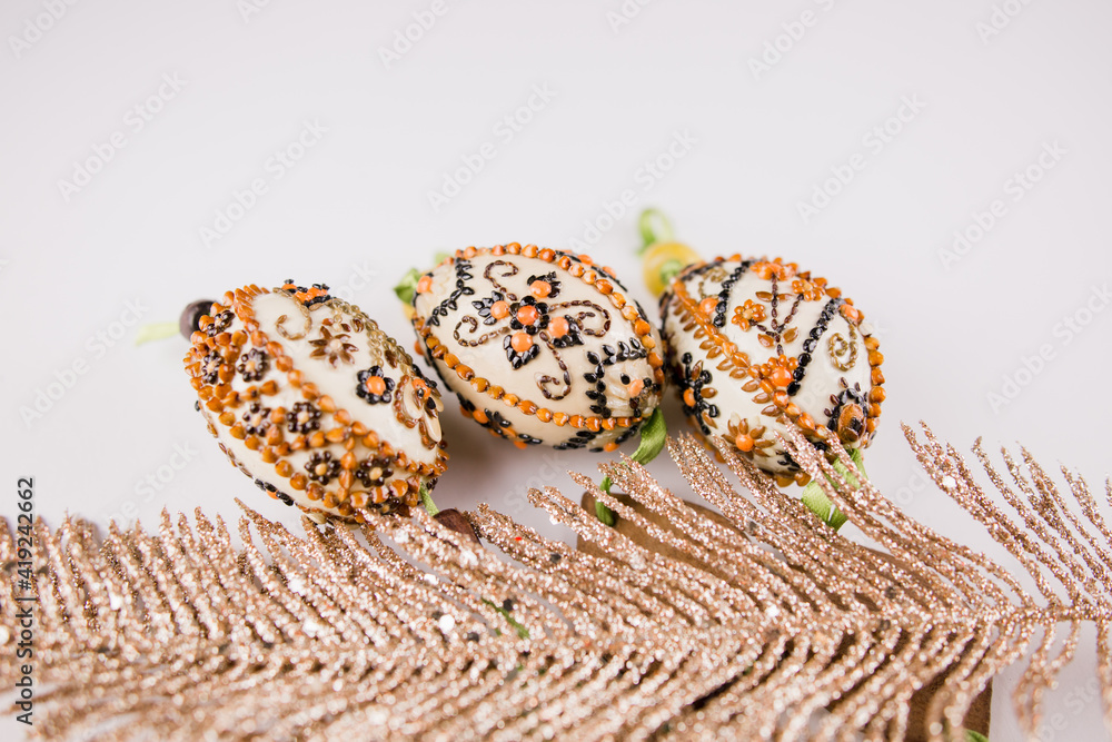 Fototapeta premium decorated easter eggs with feathers on a white background