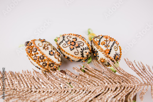 decorated easter eggs with feathers on a white background