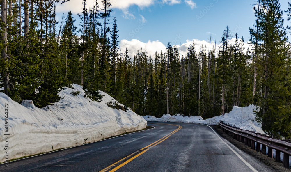 Asphalt road to Yellowstone National Park cleared of snow in early spring, US Asphalt road to Yellowstone National Park cleared of snow in early spring, US
