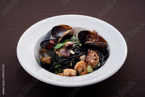 Italian pasta with seafood. Traditional Italian cuisine - homemade pasta with shrimp, mussels and Italian herbs. photo