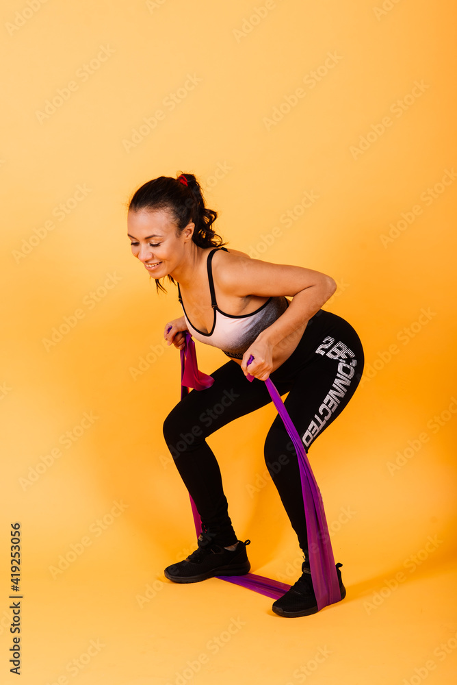 Attractive young african american sports fitness woman in sportswear working out, stretching legs Attractive young african american sports fitness woman in sportswear working out, stretching legs