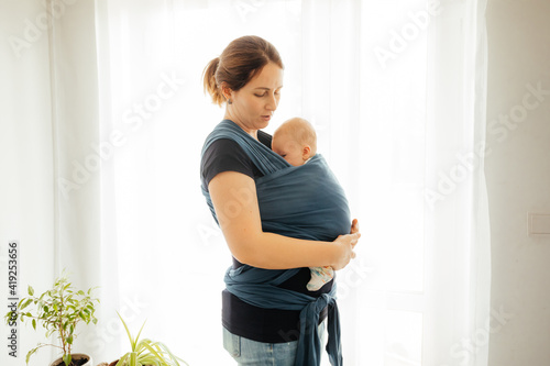 Bild auf Leinwand Happy mother with sleeping newborn in baby carrier