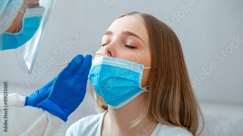 Doctor taking nasopharyngeal culture  PCR test to woman patient. Nurse take saliva sample through nose with cotton swab to check coronavirus covid 19. Long web banner