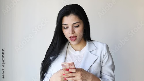 Excited woman receiving good news indoors. Happy girl texting message in studio