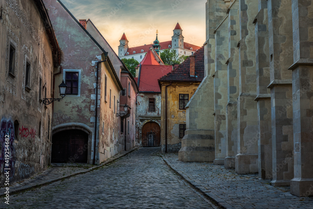 Obraz na płótnie Farska Street in Historical Centre of Bratislava, Slovakia at Sunset with Bratislava Castle in Background w salonie