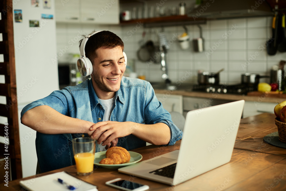 Happy man having video call over laptop while working at home. Happy man having video call over laptop while working at home.