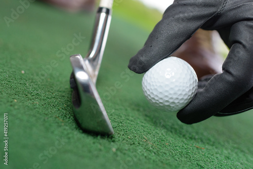 Photos hand hold golf ball with tee on course