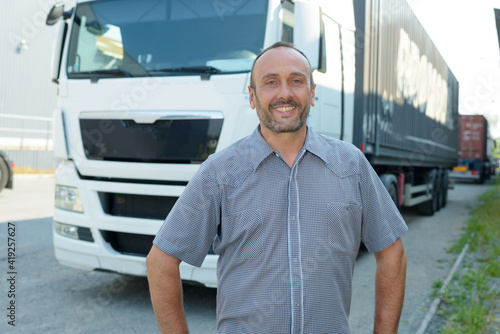 man posing in front of cargo truck