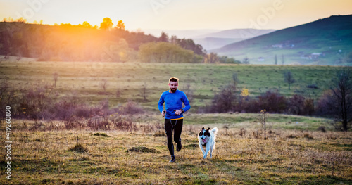 trail runner and his dog running photo