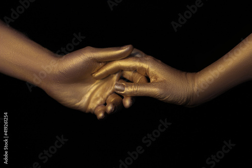 hands covered with gold steam paint. Hands of lovers. Hands in gold. Love