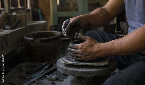 Obraz na płótnie Asian professional artisan potter making art pot or vase handicraft on wheel w salonie