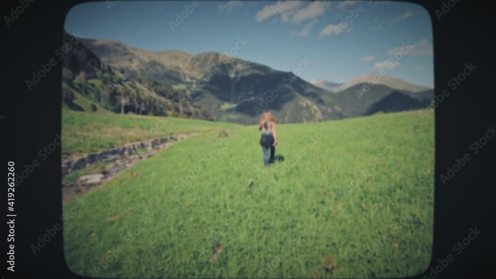 custom made wallpaper toronto digitalWoman walking on a grassy field in the mountains on a summer day. Vintage Film Look.