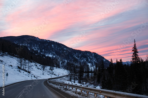pink dawn on a winter road in the mountains
