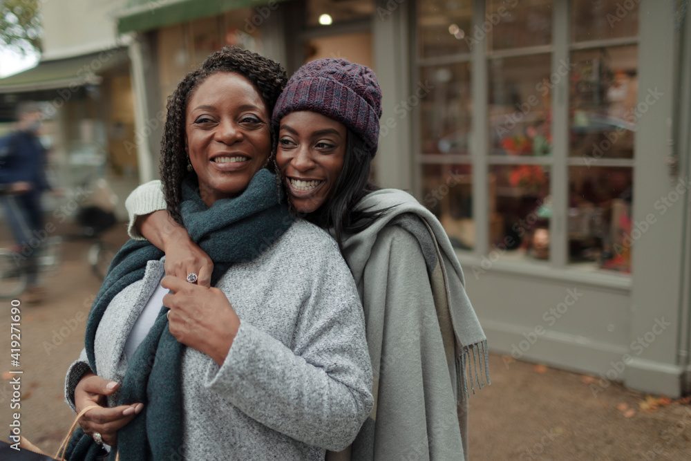 Portrait happy mother and daughter hugging on sidewalk Portrait happy mother and daughter hugging on sidewalk