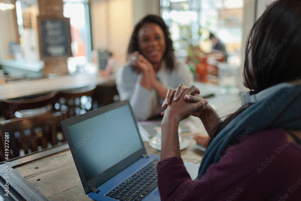 Businesswomen meeting at laptop in cafe Businesswomen meeting at laptop in cafe