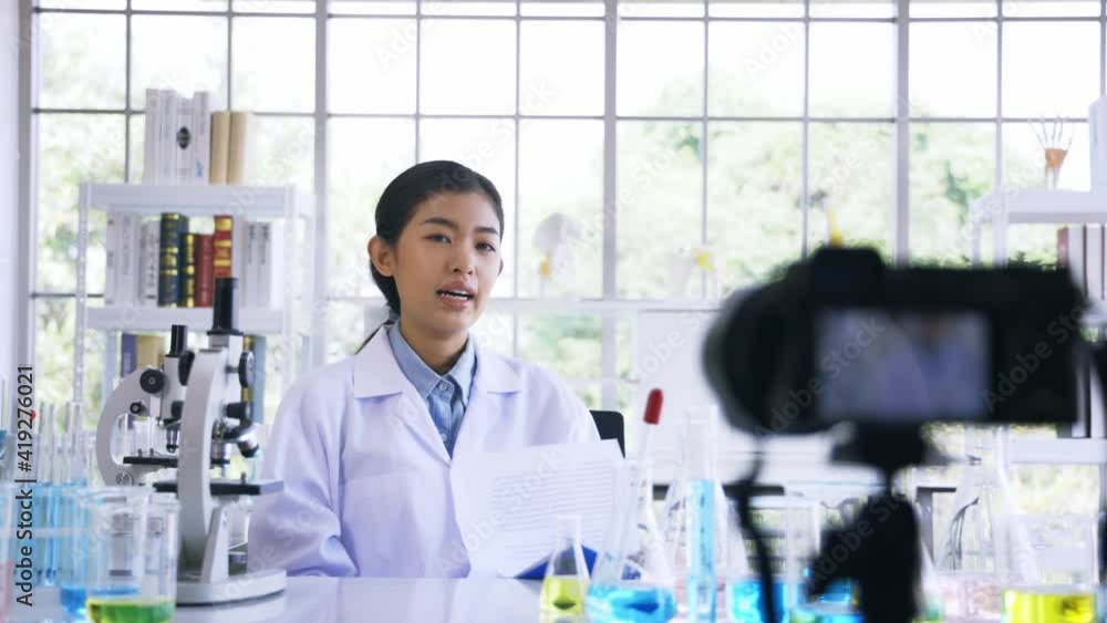 Portrait of young female doctor wearing lab coat recording online video class and vlog on medical research and science experiments in laboratory Portrait of young female doctor wearing lab coat recording online video class and vlog on medical research and science experiments in laboratory