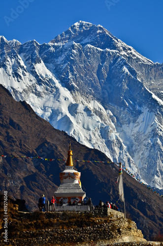 Trekkers stop by a buddhist stupa to rest and enjoy the view of Mount Everest (8.848m) on the way to its Base Camp, Sagarmatha National Park, Solukhumbu, Nepal