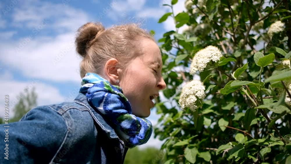 Woman sneezing from flowering tree. Concept: seasonal allergy Woman sneezing from flowering tree. Concept: seasonal allergy