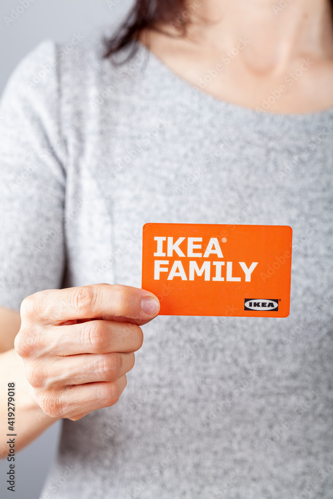 Clarksburg, MD, USA 02-25-2021: A caucasian woman is holding an Ikea Family  membership card in her hand. This card offers in store and online shopping  discounts on eligible purchases from Ikea. Stock