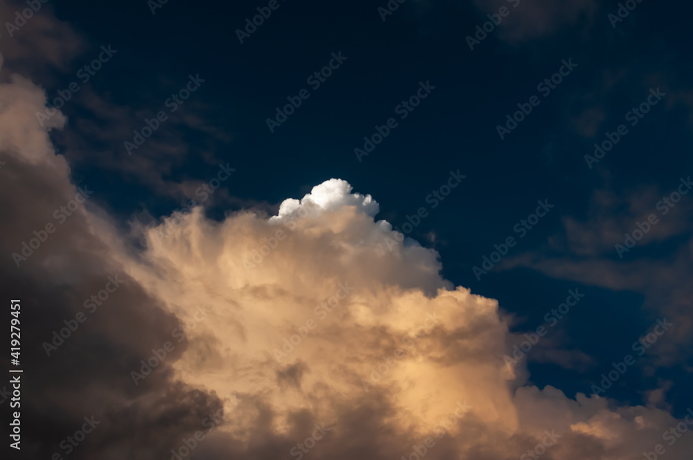 Obraz premium Cumulunimbus clouds with a dense formation illuminated by a sunlight.