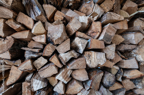 Closeup photograph of an outdoor pile of stacked split firewood