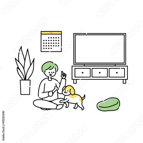 リビングで犬と一緒に遊ぶ男性