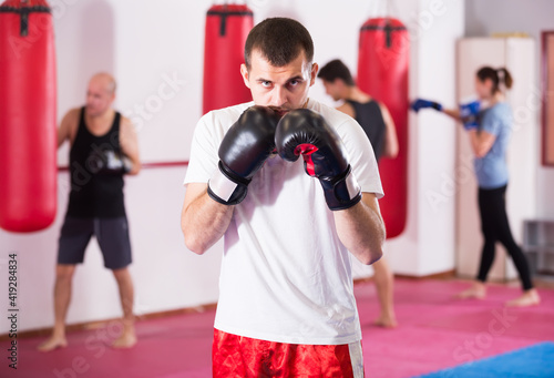 concentrated sportsman in the boxing hall practicing boxing punches during training © JackF