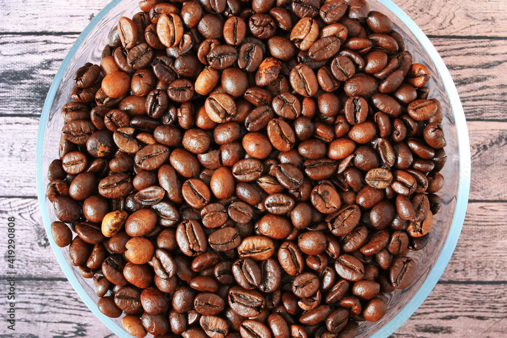 Fototapeta premium Brown coffee beans lie on a plate