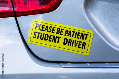 Please Be Patient Student Driver - yellow bumper sticker on the car.