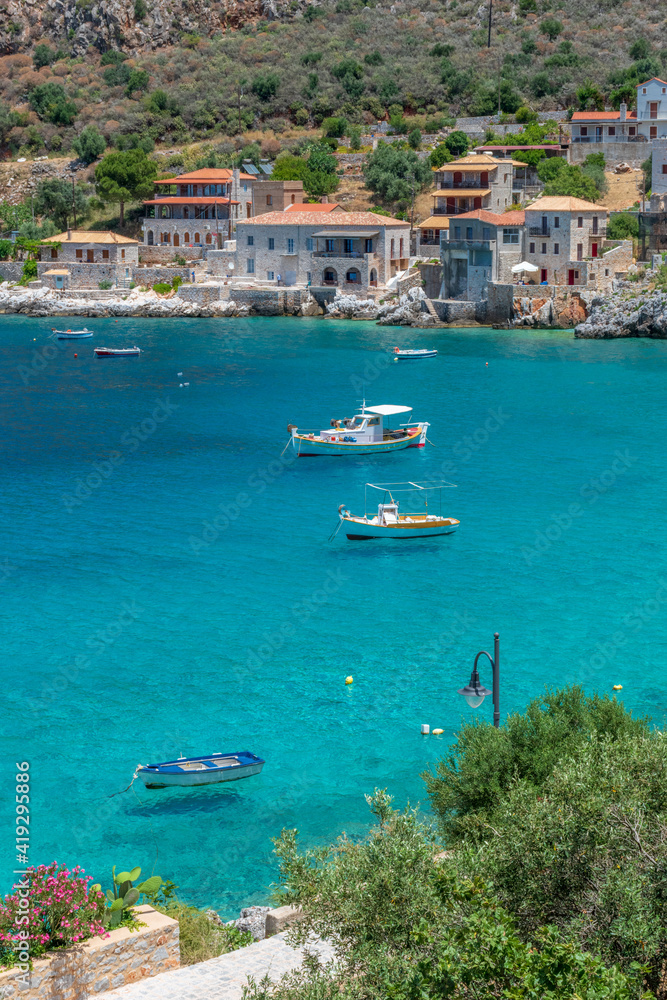 view of Limeni village with fishing boats in turquoise waters and the stone buildings as a background in Mani, South Peloponnese , Greece. view of Limeni village with fishing boats in turquoise waters and the stone buildings as a background in Mani, South Peloponnese , Greece.
