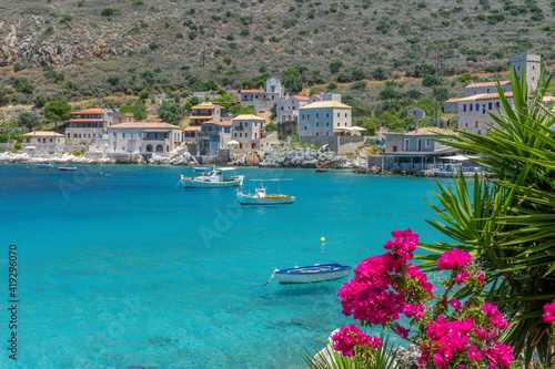 Limeni village with the famous stone buildings a blooming bougainvillea, and turquoise waters in Mani, South Peloponnese , Greece.