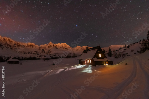 Fototapeta Naklejka Na Ścianę i Meble -  Night winter landscapes in the High Tatras, with mountain houses on a background of snow-capped mountains and starry sky