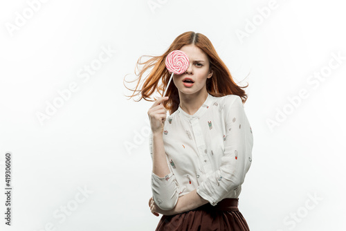 pretty red-haired woman with lollipop in hands emotions cropped view studio